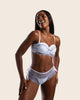 Modelo em lingerie branca representa a nova coleção que une luxo e conforto para valorizar a beleza feminina